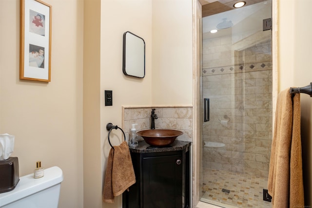 bathroom featuring vanity, toilet, and a shower with door