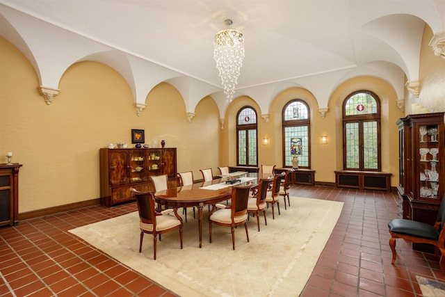 dining space with dark tile patterned floors and a chandelier