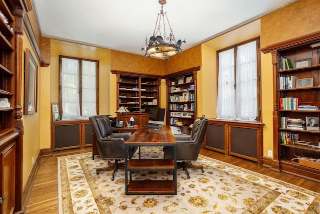 office area with crown molding, hardwood / wood-style floors, and a notable chandelier