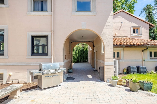 doorway to property with cooling unit and a patio