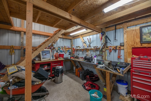 misc room with carpet flooring, a workshop area, and wood walls