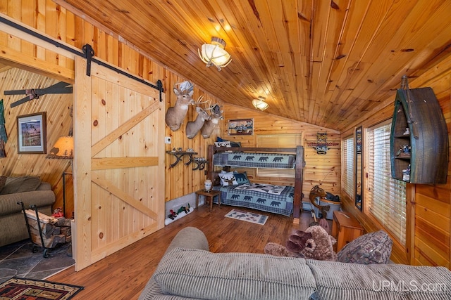 living room featuring vaulted ceiling, dark wood-type flooring, a barn door, wooden ceiling, and wood walls