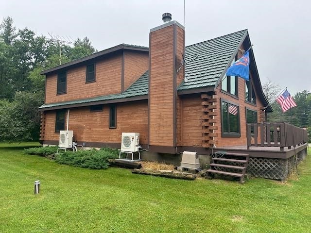 back of property featuring a lawn and a wooden deck