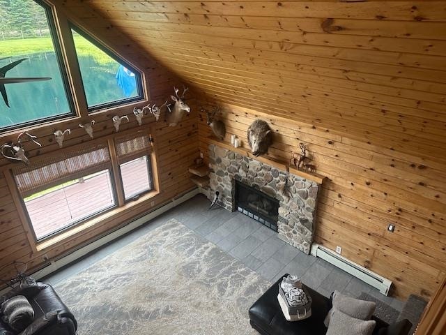 unfurnished living room with a fireplace, lofted ceiling, plenty of natural light, wooden ceiling, and a baseboard heating unit