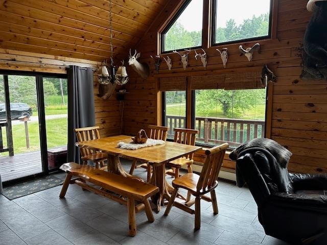 dining area featuring wood ceiling, tile patterned flooring, wooden walls, and vaulted ceiling