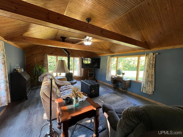 living room with vaulted ceiling with beams, wood finished floors, a wealth of natural light, and baseboards