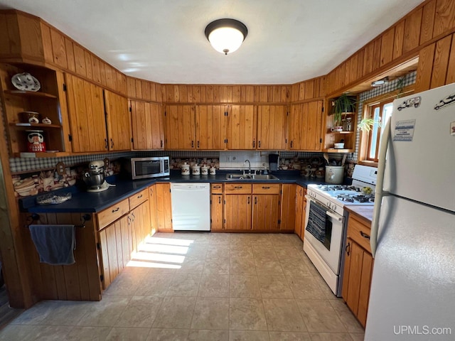 kitchen featuring dark countertops, white appliances, open shelves, and a sink