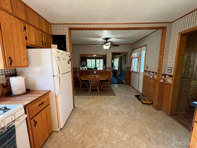 kitchen featuring ceiling fan, white appliances, light countertops, brown cabinets, and wallpapered walls