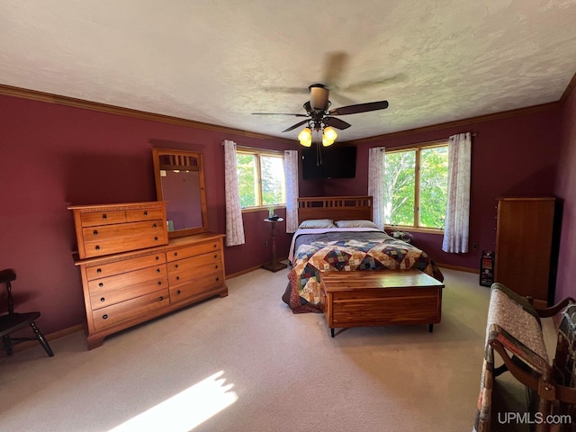 bedroom with ceiling fan, a textured ceiling, light carpet, baseboards, and ornamental molding