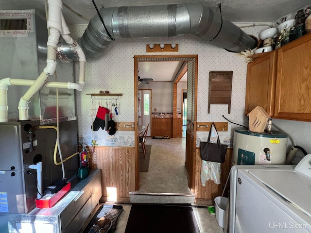 laundry room with washer / dryer, water heater, cabinet space, and wallpapered walls