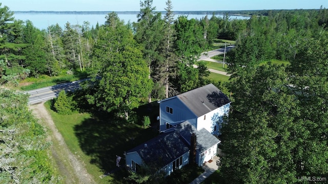 birds eye view of property with a forest view and a water view