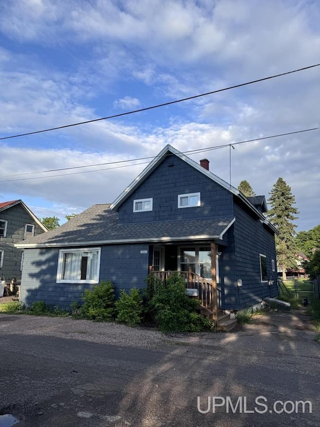 view of front facade with a porch and roof with shingles