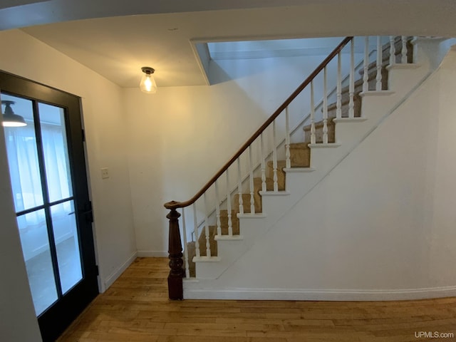 foyer entrance with stairway, baseboards, and hardwood / wood-style flooring