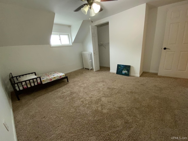 bonus room with carpet flooring, ceiling fan, radiator, and lofted ceiling