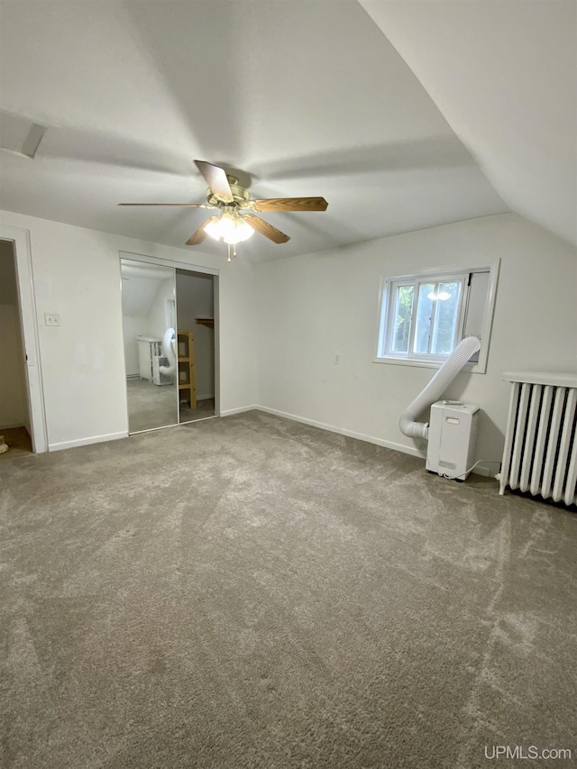 interior space with lofted ceiling, a closet, carpet flooring, ceiling fan, and baseboards