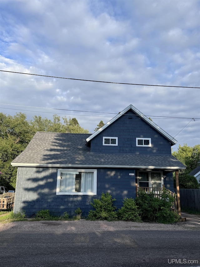 view of front of property with covered porch and a shingled roof