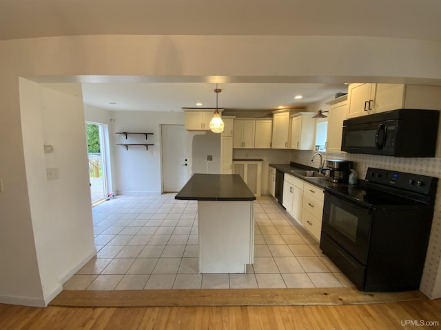 kitchen with a kitchen island, a sink, decorative backsplash, black appliances, and dark countertops