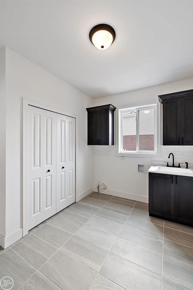 washroom featuring cabinets, washer hookup, sink, and light tile patterned flooring