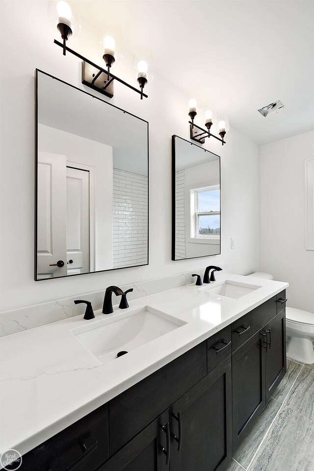 bathroom with a chandelier, wood-type flooring, vanity, and toilet