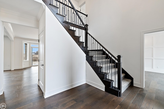 stairs featuring wood-type flooring and ornamental molding