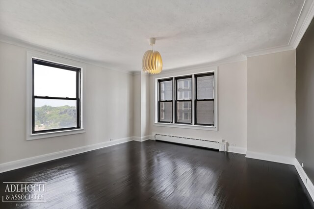 spare room with a baseboard heating unit, ornamental molding, dark wood-type flooring, and a textured ceiling