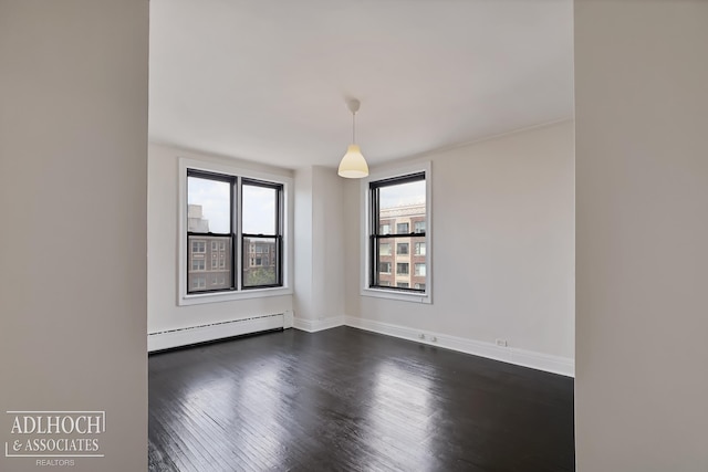 spare room featuring dark hardwood / wood-style flooring and a baseboard radiator