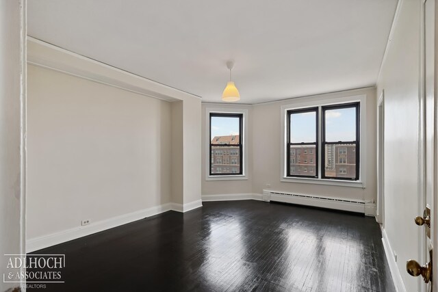 unfurnished room with a baseboard heating unit, plenty of natural light, and dark hardwood / wood-style flooring