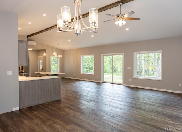 unfurnished living room featuring dark hardwood / wood-style floors, a wall unit AC, lofted ceiling with beams, and ceiling fan with notable chandelier