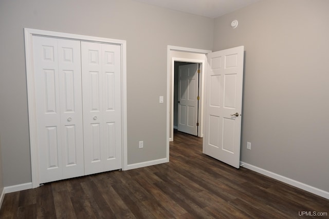 unfurnished bedroom with dark hardwood / wood-style floors and a closet