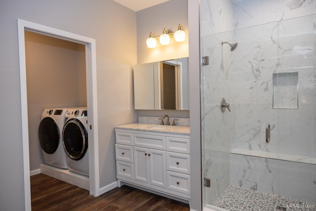 bathroom with separate washer and dryer, a shower with shower door, vanity, and wood-type flooring