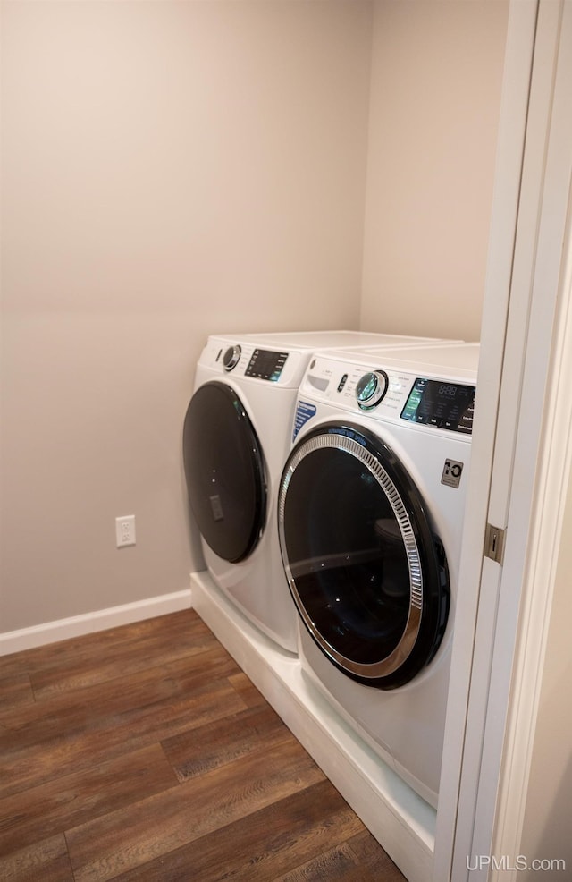 washroom with dark hardwood / wood-style floors and washing machine and clothes dryer