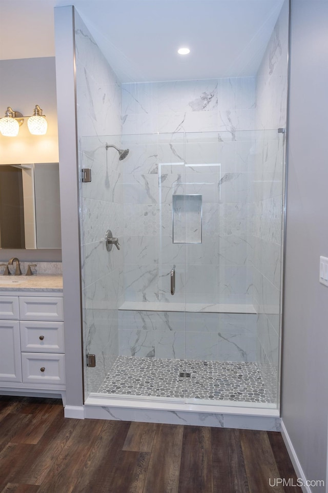 bathroom featuring an enclosed shower, large vanity, and wood-type flooring