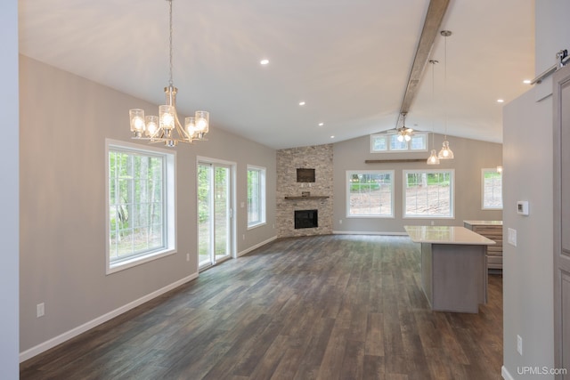 unfurnished living room featuring beam ceiling, a healthy amount of sunlight, and dark hardwood / wood-style flooring