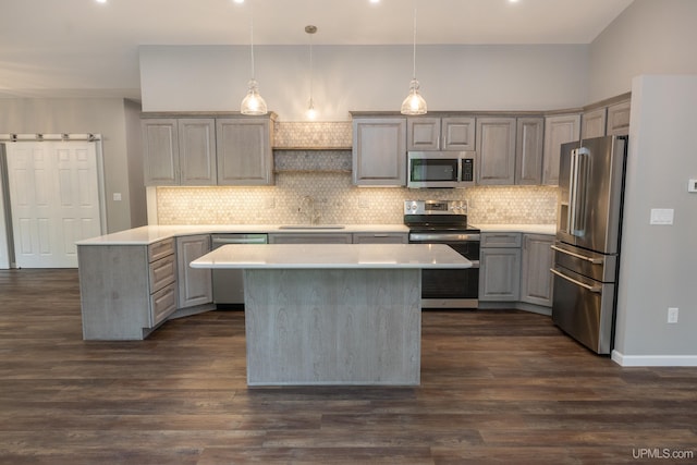 kitchen with stainless steel appliances, dark wood-type flooring, tasteful backsplash, and a kitchen island