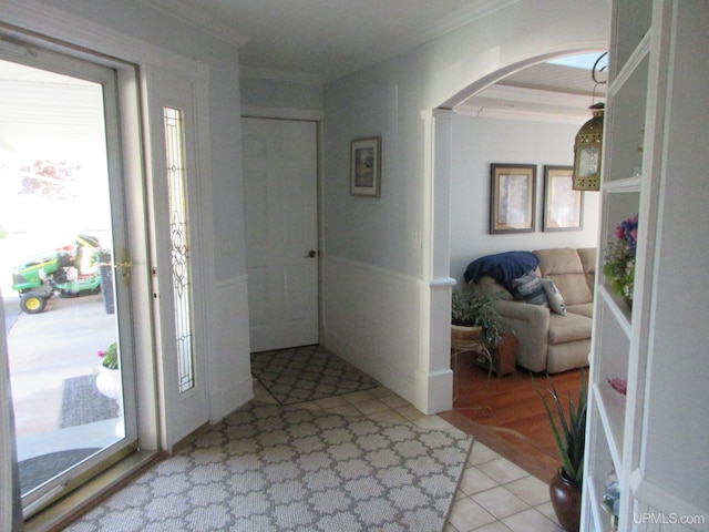 tiled foyer entrance featuring ornamental molding and a healthy amount of sunlight