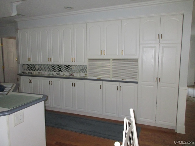 kitchen with white cabinets, dark hardwood / wood-style floors, and tasteful backsplash