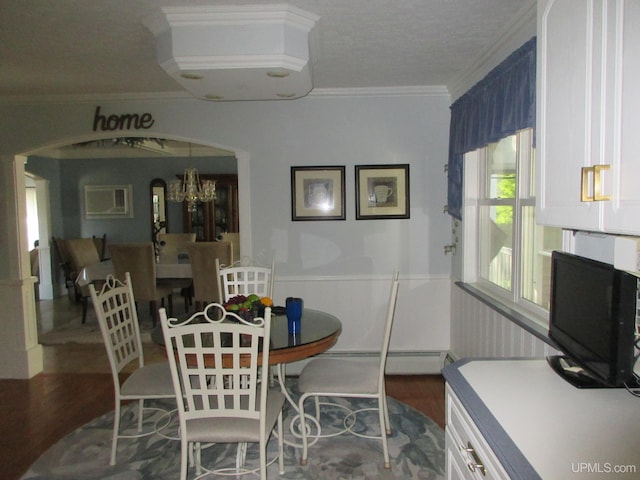 dining room with crown molding, hardwood / wood-style floors, a baseboard radiator, and a notable chandelier