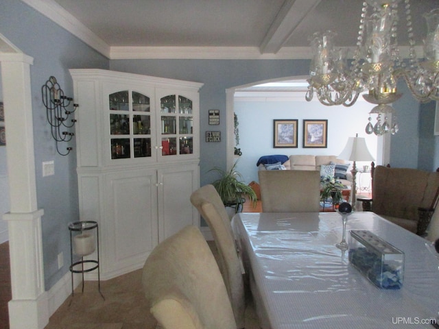 dining area with ornamental molding, beamed ceiling, and a chandelier