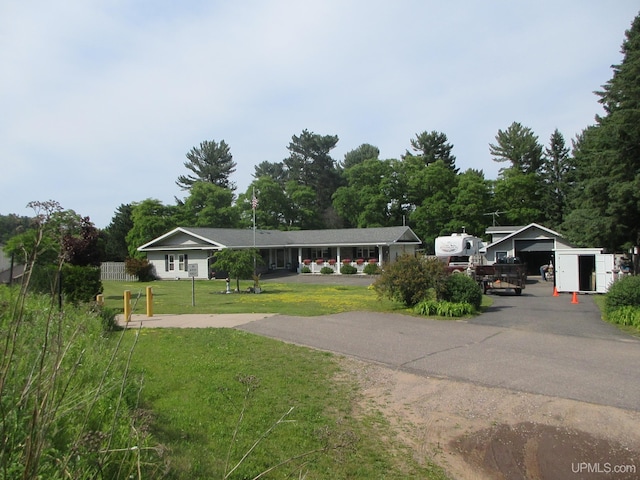 view of front of property featuring a garage, a front lawn, and a carport