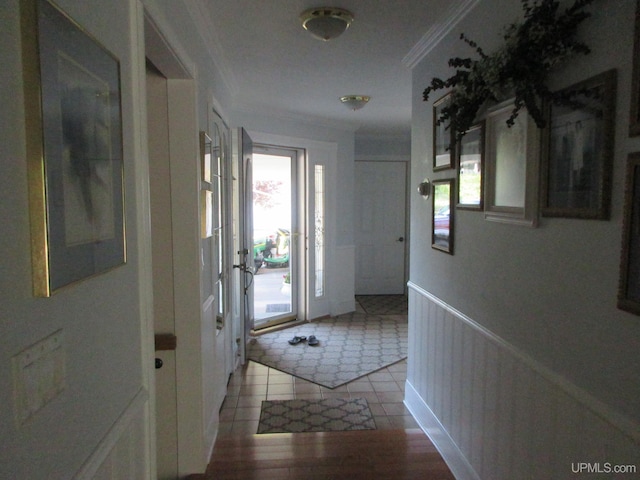 corridor with a wealth of natural light, crown molding, and light hardwood / wood-style flooring