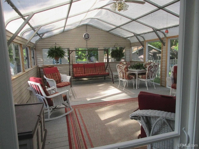 sunroom with ceiling fan and vaulted ceiling