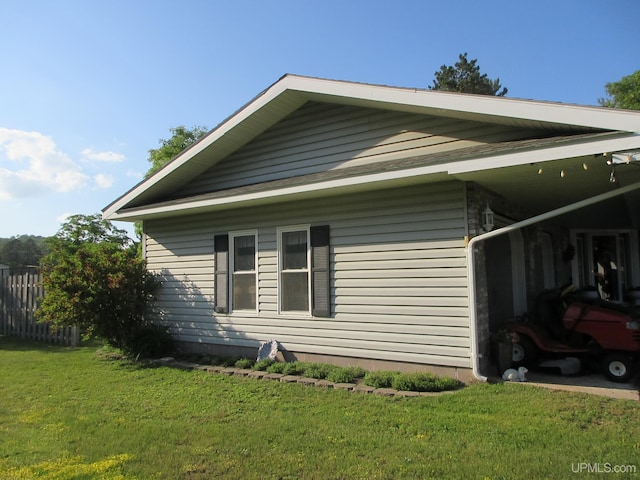 view of side of home with a yard and a carport