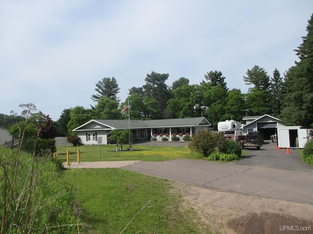 view of front of home with a garage, a carport, and a front lawn