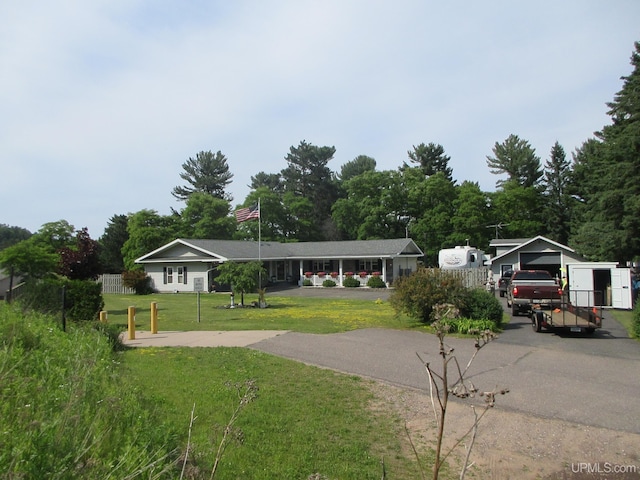 view of front of house featuring an outdoor structure, a garage, a carport, and a front lawn