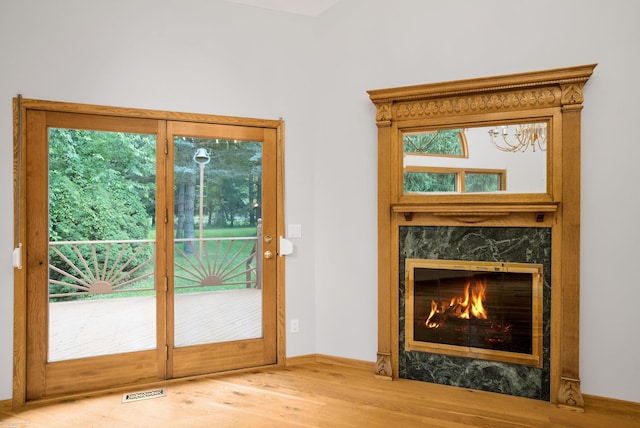 entryway with a high end fireplace and wood-type flooring