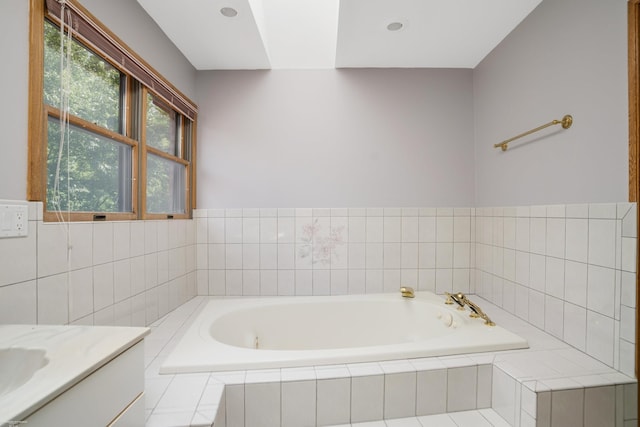 bathroom featuring vanity and tiled bath