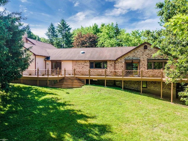 back of property featuring a lawn and a wooden deck