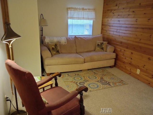 carpeted living room featuring wood walls