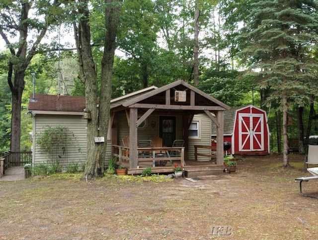 view of front facade with a wooden deck and a storage shed