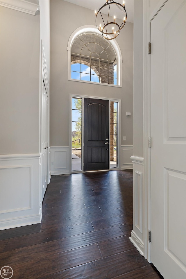 entrance foyer with dark hardwood / wood-style floors and a chandelier